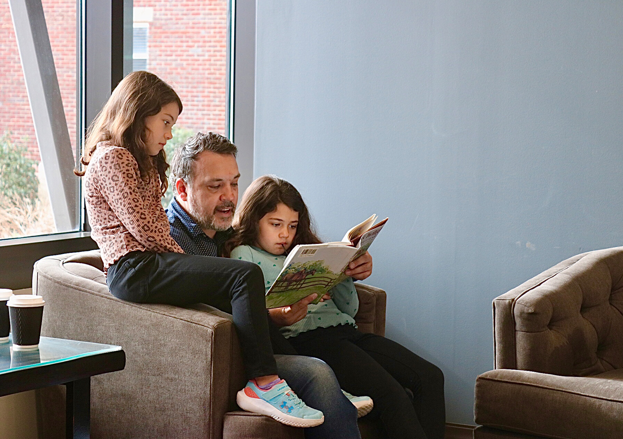 girl with mother and father holding hands on the nature. Child with parents outdoors